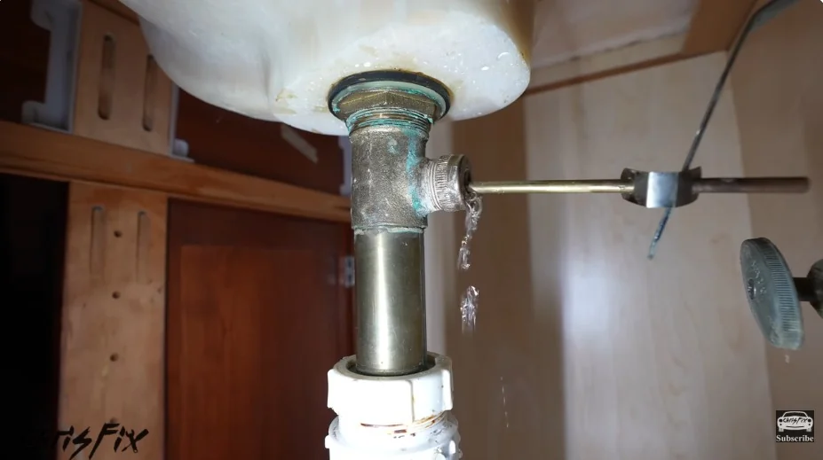 Water dripping from a sink drain fitting, a sign of a plumbing leak
